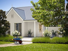 Neutral Californian Bungalow White Fascia Gable and Dark Grey Roof and Trees with Grass